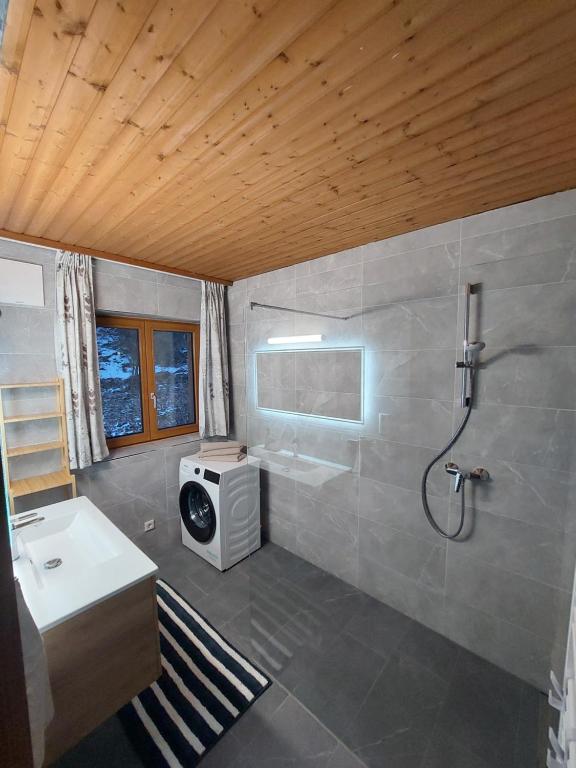 uma casa de banho com um chuveiro, um lavatório e um WC. em Stony Sea Apartments em Saalfelden am Steinernen Meer