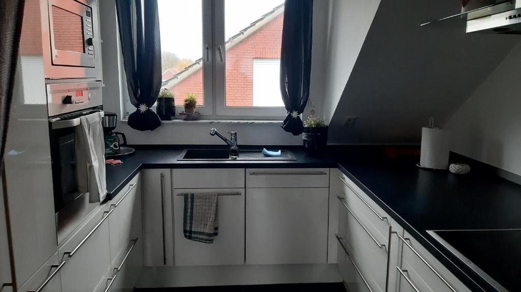 eine weiße Küche mit einem Waschbecken und einem Fenster in der Unterkunft Wohnung mit 5 Einzelzimmern in Selm