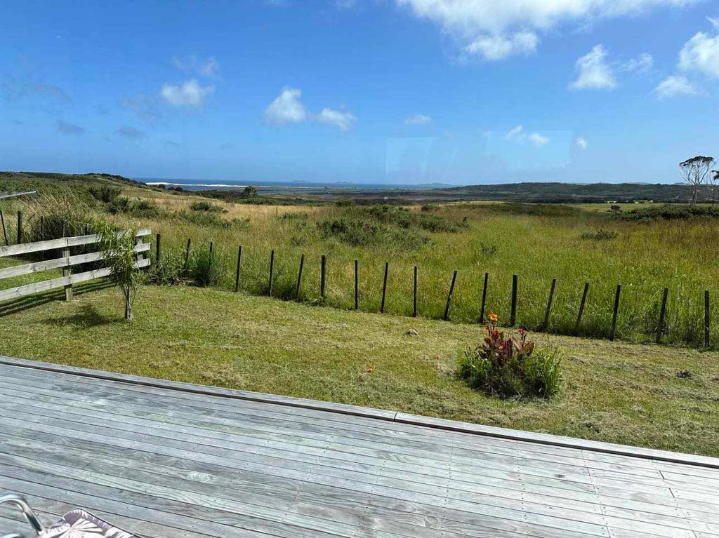 a fence next to a field with a field sidx sidx sidx at Seascape Peninsula Bach in Kaitaia