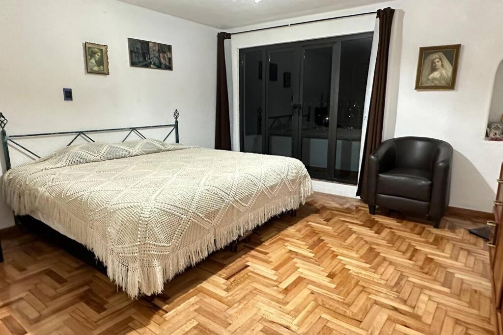 1 dormitorio con 1 cama y 1 silla negra en Casa amplia con vista de altura en Toluca