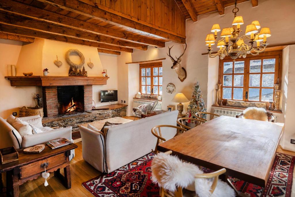 een woonkamer met een tafel en een open haard bij Pleta Ordino 51, Duplex rustico con chimenea, Ordino, zona Vallnord in Ordino