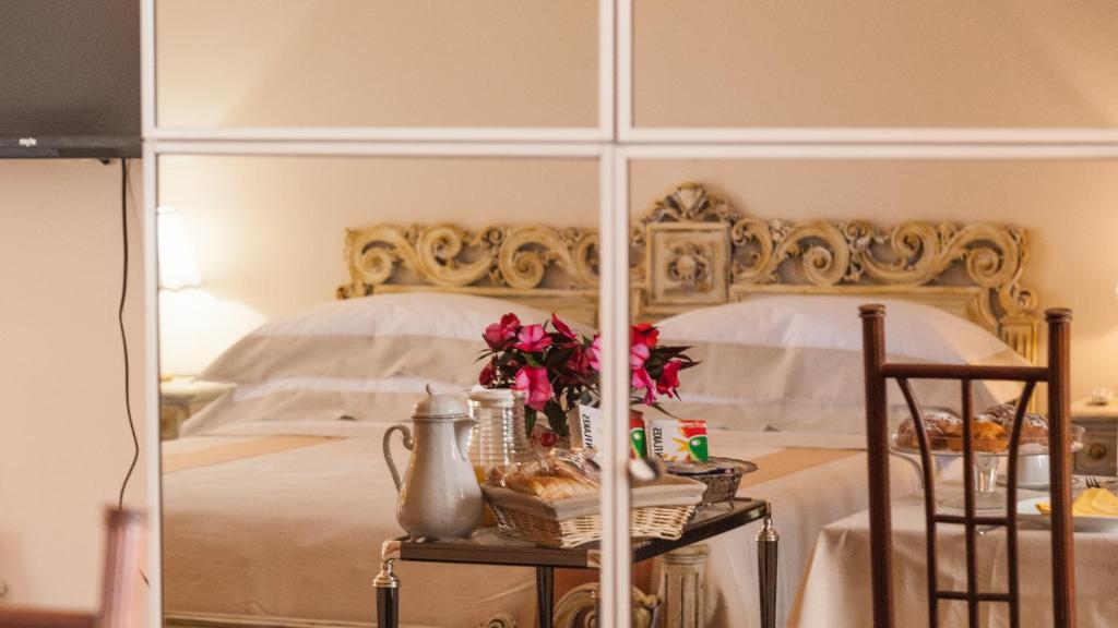 1 dormitorio con 1 cama blanca grande y espejo en Boutique Villa Magnolia Luxury Suites, en Nardò