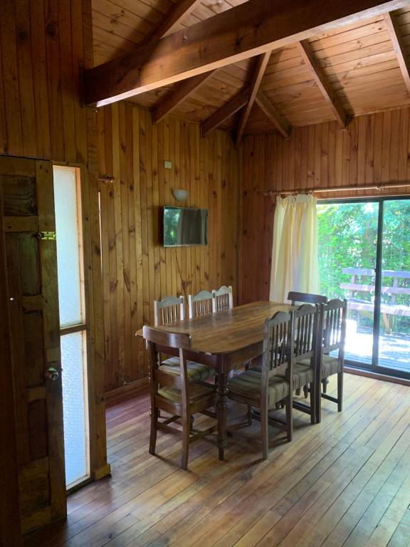 uma sala de jantar em madeira com uma mesa e cadeiras em madeira em Cabañas pucon em Pucón