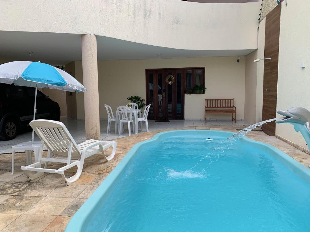 納塔爾的住宿－Casa 3 suítes com piscina，一座游泳池,里面喷水着鸟