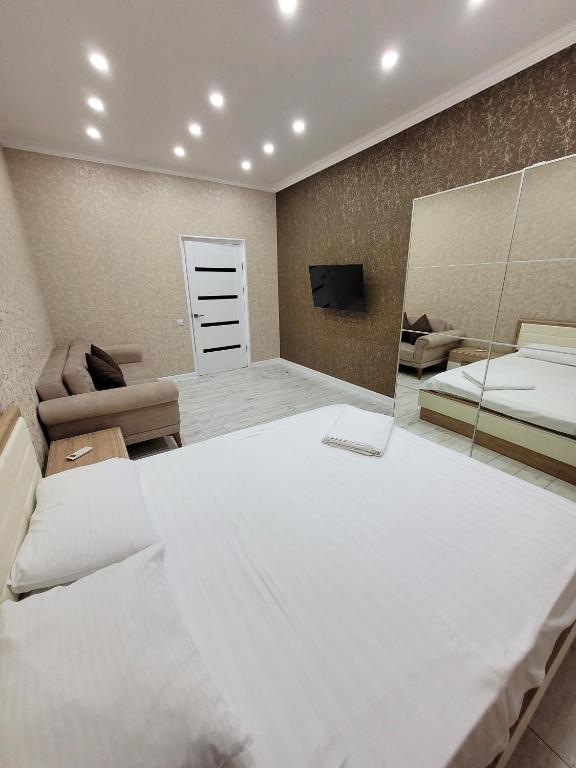 - une chambre avec un grand lit et un miroir dans l'établissement Однокомнатные бизнес апартаменты в ЖК Заман, à Atyraū