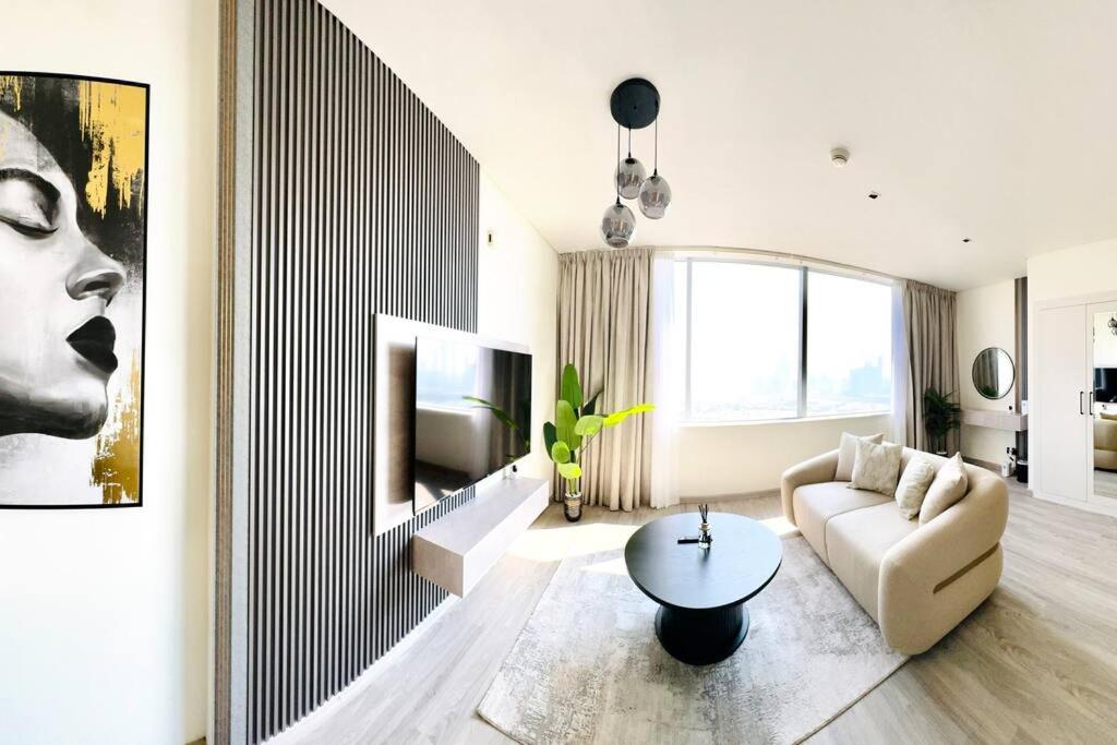 a living room with a couch and a tv at Best Spacious Studio at Sky Gardens DIFC in Dubai