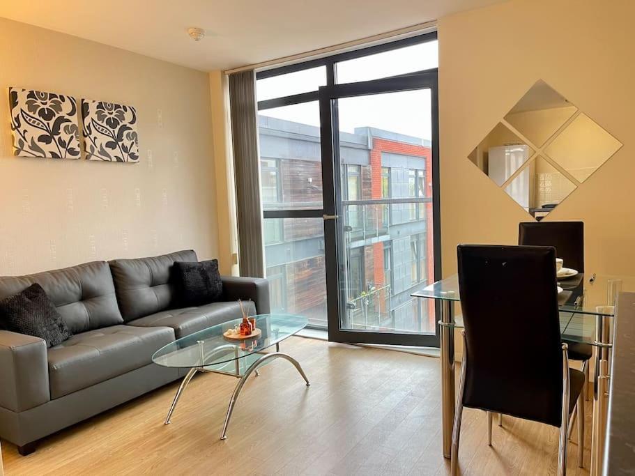 a living room with a couch and a glass table at 1 BED MODERN APARTMENT WITH FREE PARKING, SHEFFIELD CITY CENTRE in Sheffield