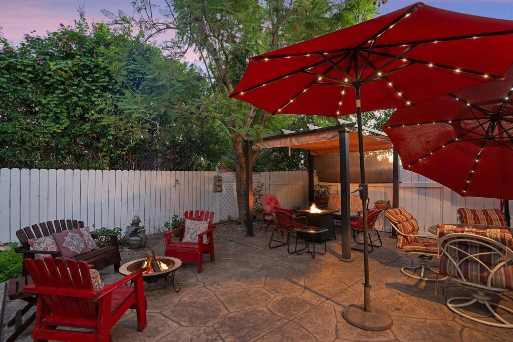 un patio con sillas, mesas y una sombrilla roja en Casa Serena - Peaceful Family Retreat, en La Mesa