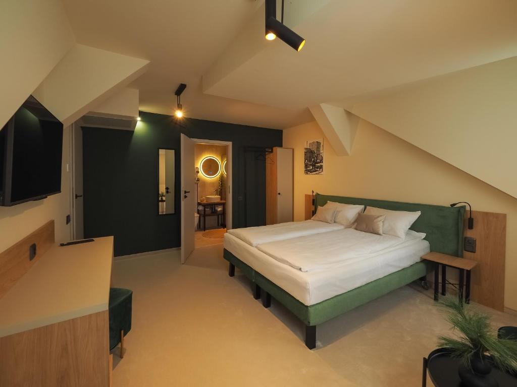 1 dormitorio con 1 cama grande y cabecero verde en Craft Inn - Boutique Hotel, en Sibiu