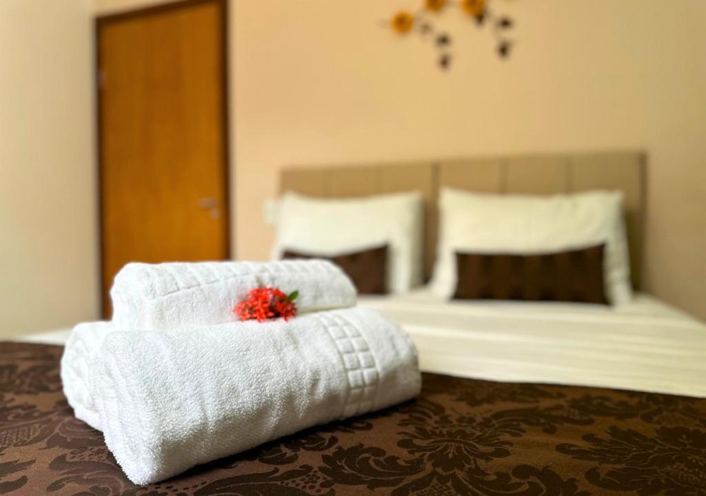 Habitación de hotel con 1 cama con toallas y 1 cama en Shalom Pousada Capitólio en Capitólio