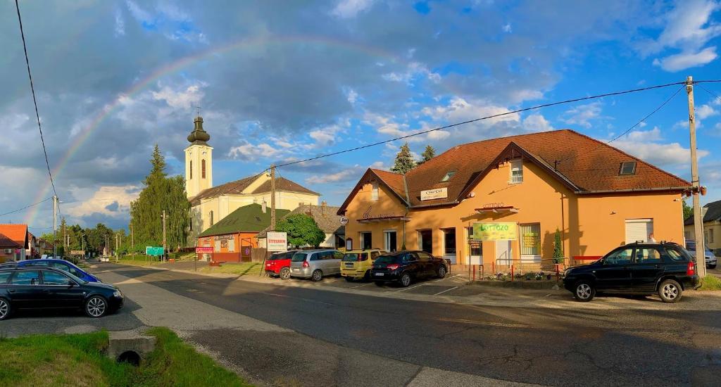 una iglesia con coches estacionados frente a una calle en Csata Vendéglő és Panzió, en Isaszeg