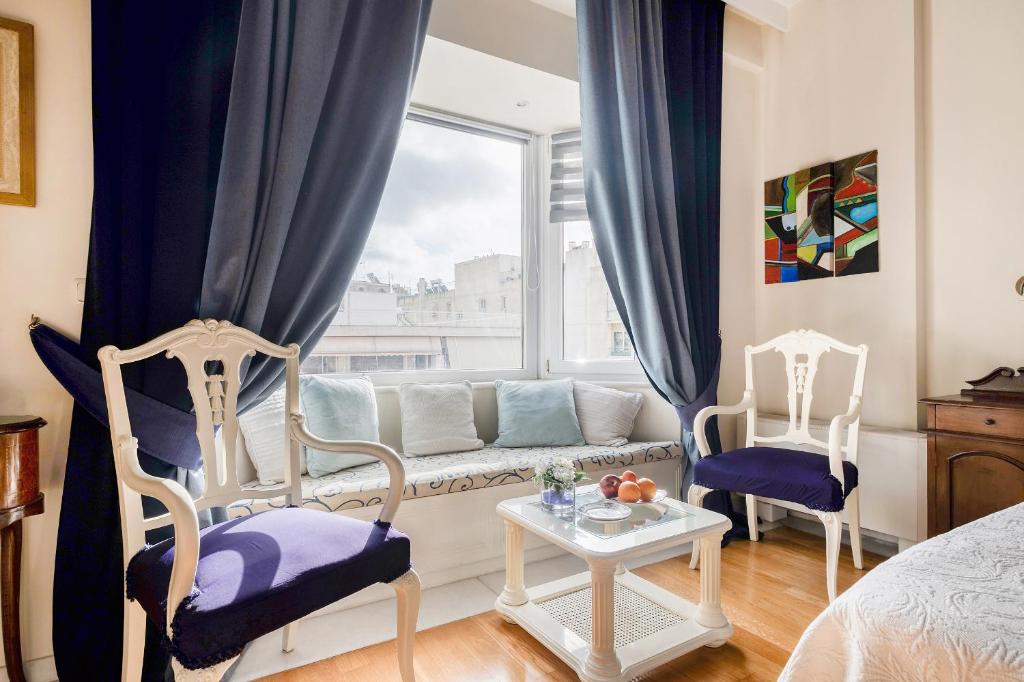 sala de estar con sofá, 2 sillas y ventana en Artistic Villa Luxury, en Atenas
