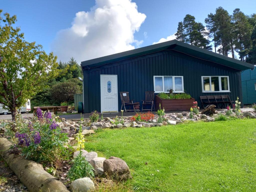 ein kleines blaues Haus mit Garten davor in der Unterkunft The Boathouse in Longmorn