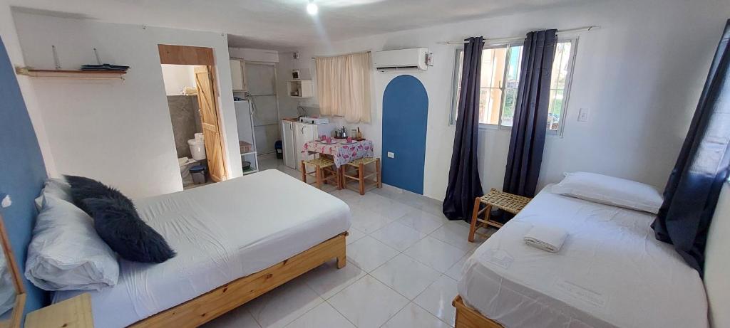 1 dormitorio pequeño con 2 camas y mesa en Apartamento Los Blancos, a dos Minutos de los Patos Barahona, en Enriquillo