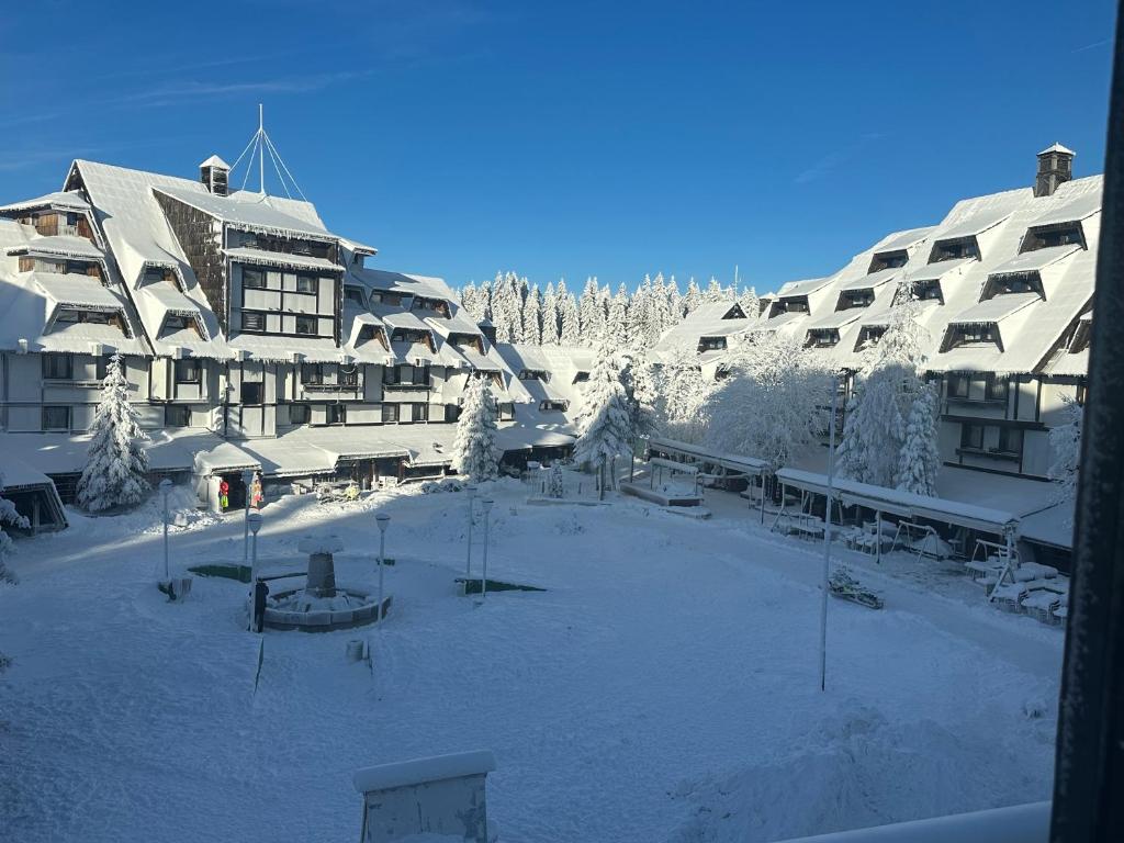a large building with snow on the ground in front of it at Konaci”Rile-Men” in Kopaonik