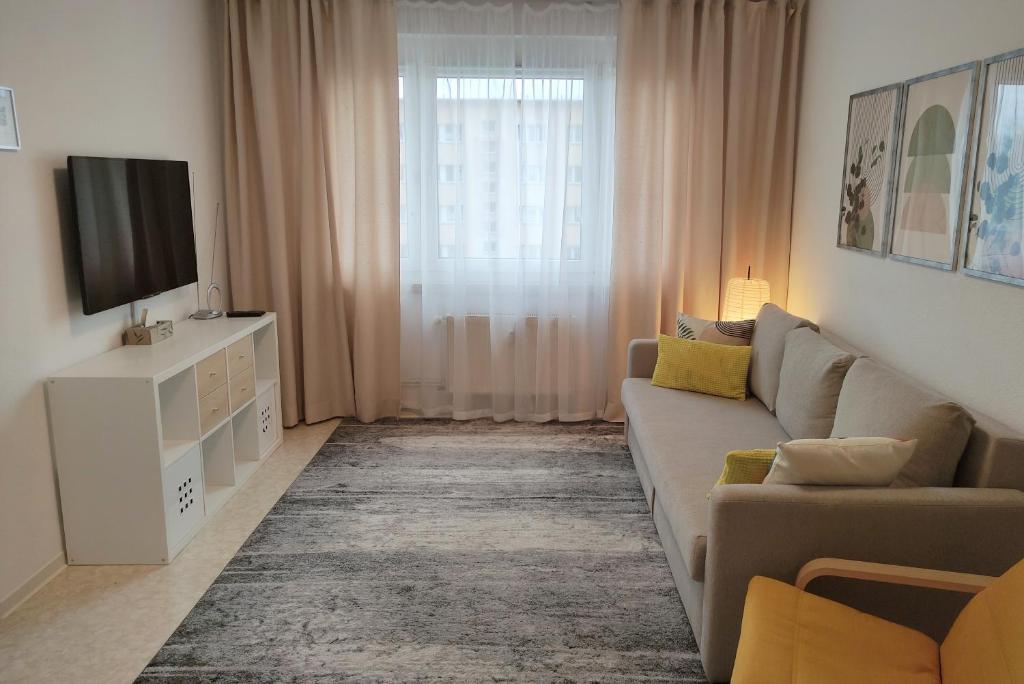sala de estar con sofá y TV en Apartment E - feel good, en Leipzig