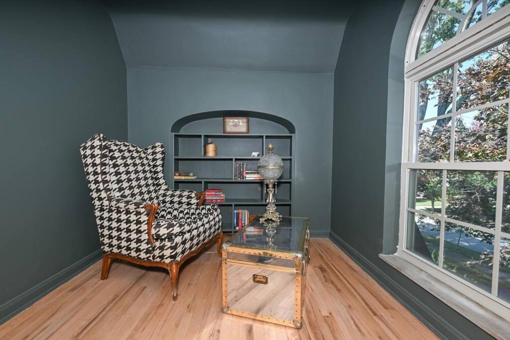 ein Wohnzimmer mit einem Stuhl und einem Tisch in der Unterkunft SuperHost PLUS ~ Designer Inspired Boynton Bungalow in Cleveland Heights