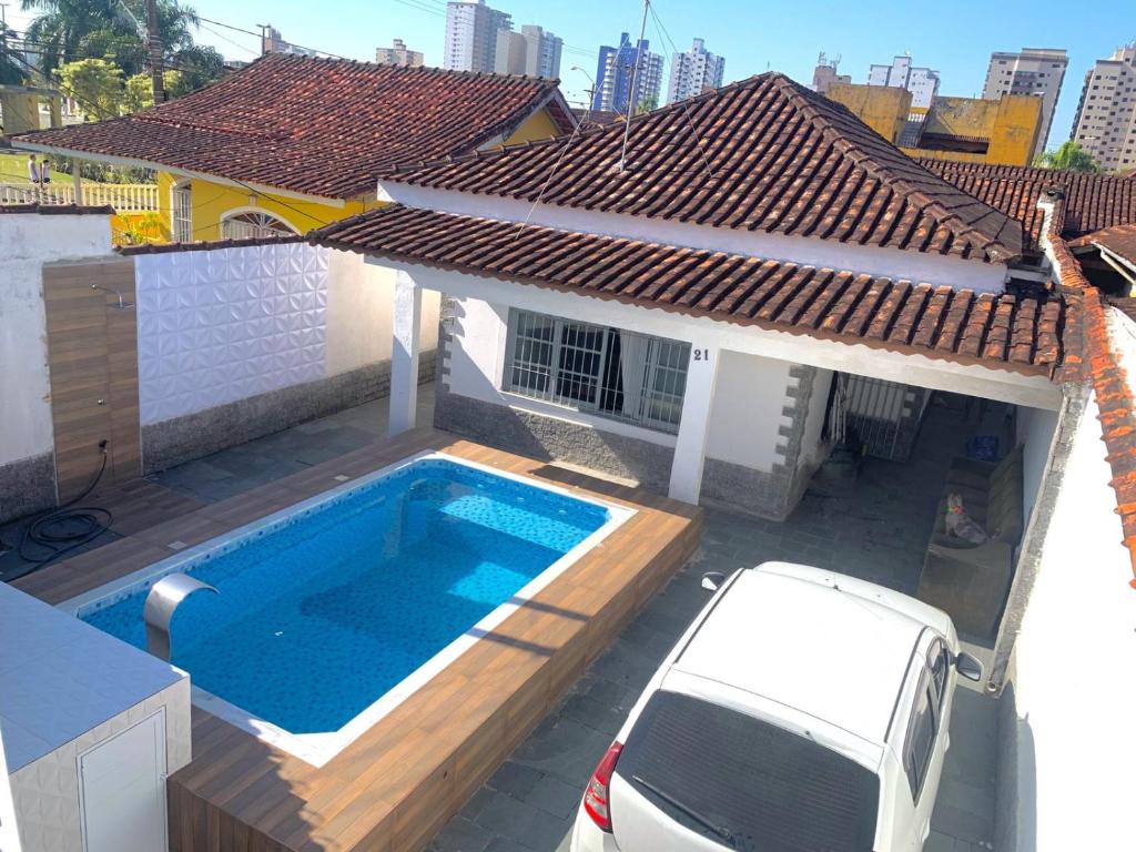 une camionnette blanche garée en face d'une maison avec piscine dans l'établissement Recanto Caiçara, à Solemar