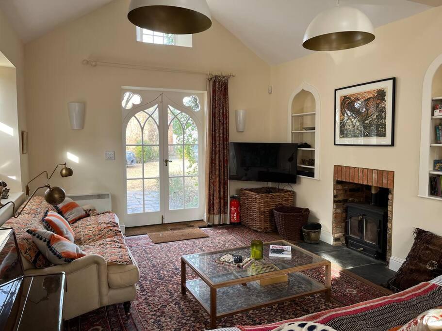 a living room with a couch and a fireplace at Charming Old Schoolroom Studio in Daventry