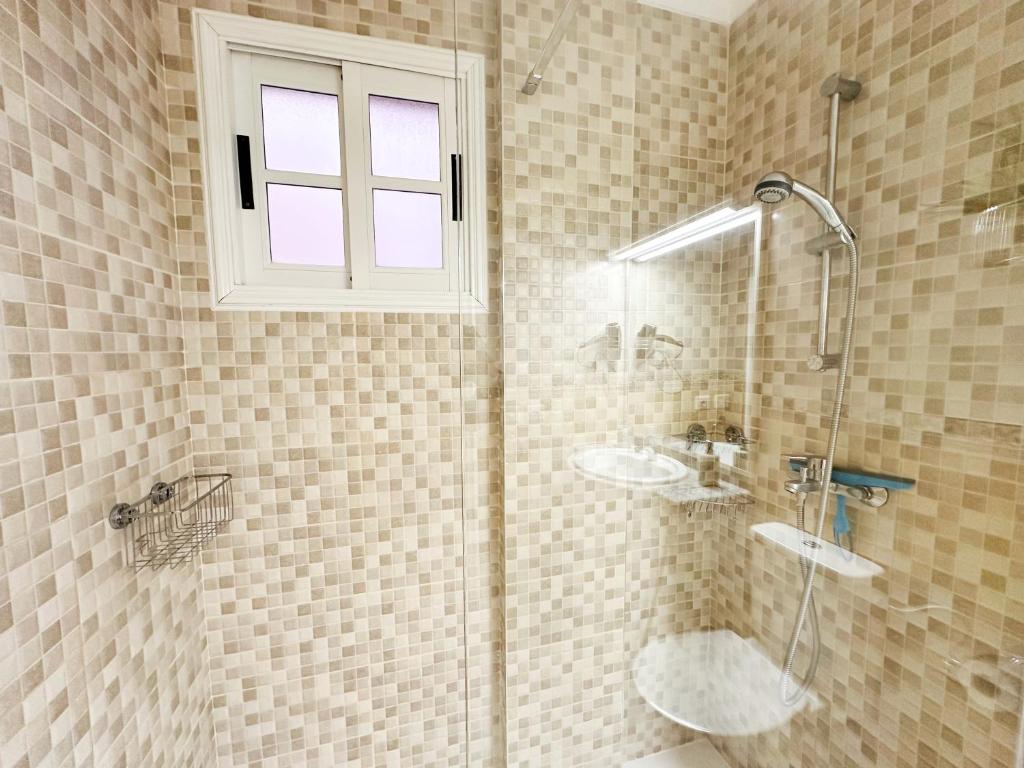 a shower with two sinks and a window in a bathroom at !!! Relaxing View, The Heights Apartment With Terrace and Heated Pools, Los Cristianos in Los Cristianos