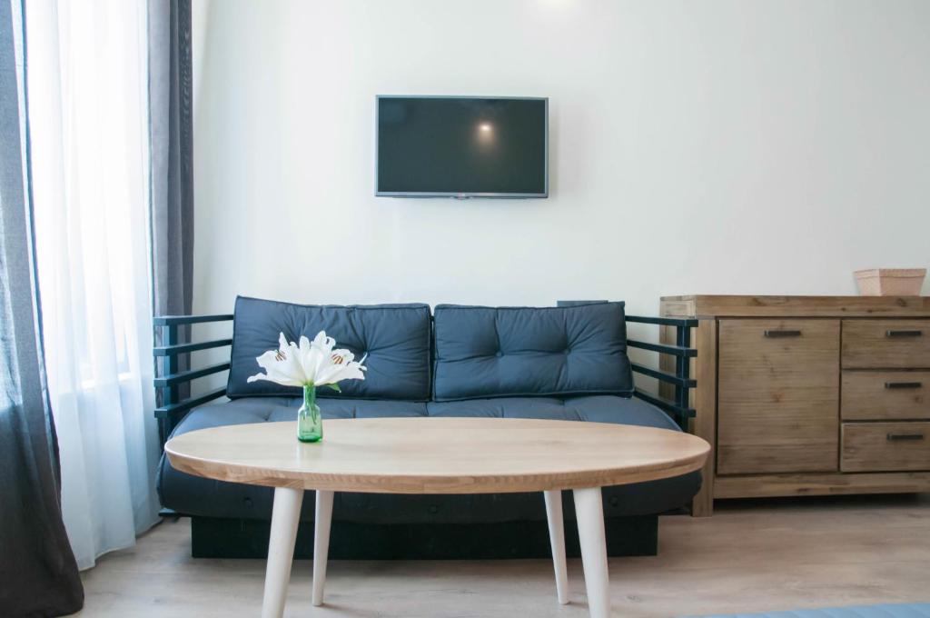 クルジュ・ナポカにあるCluj Napoca Apartmentsのリビングルーム(青いソファ、テーブル付)