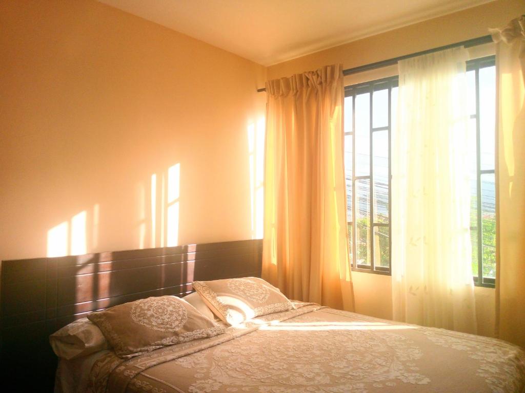een slaapkamer met een bed voor een raam bij North Family View n Wide in Cuenca