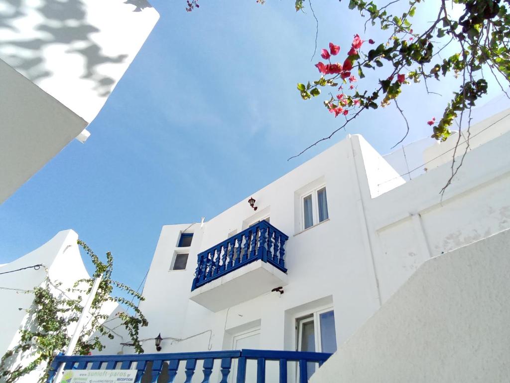 a white building with a blue balcony on it at Sunloft-Paros in Naousa