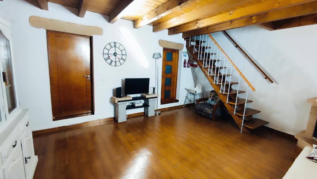 a living room with a staircase and a television at Casa Lopes in Alpalhão