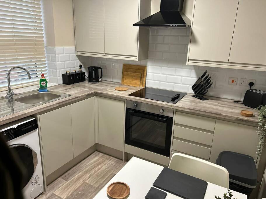 a kitchen with a sink and a stove top oven at Well Equipped Apartment In Stoke on Trent in Stoke on Trent