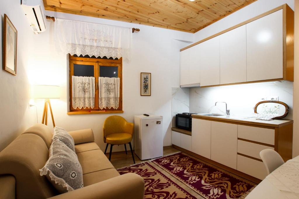 uma sala de estar com um sofá e uma cozinha em A&Fabio Guesthouse em Gjirokastër