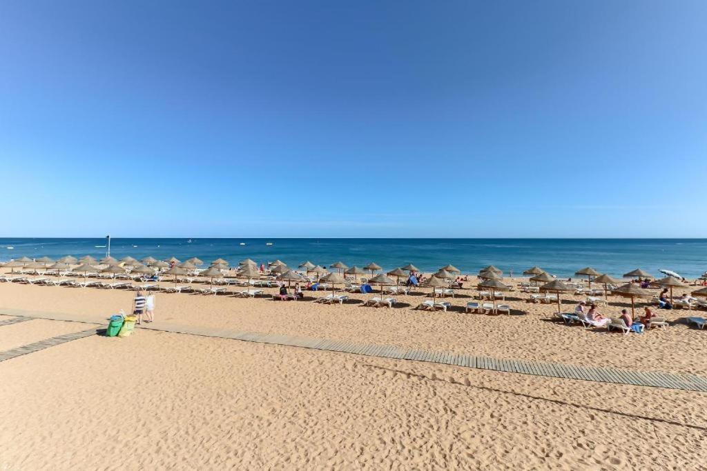 a beach with umbrellas and chairs and the ocean at SKY - TUNEL OLD TOWN in Albufeira