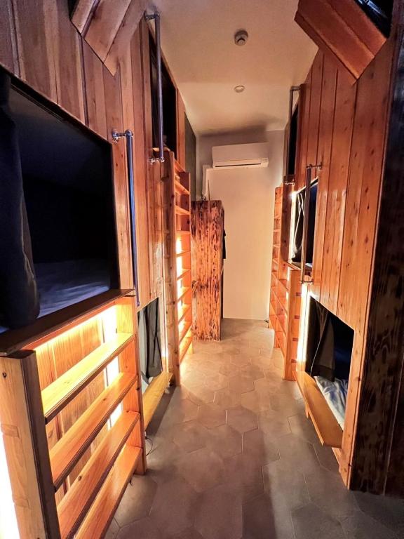 a hallway with wooden walls and a large flat screen tv at JOOOOY building 2Kai - Vacation STAY 60626v in Amami