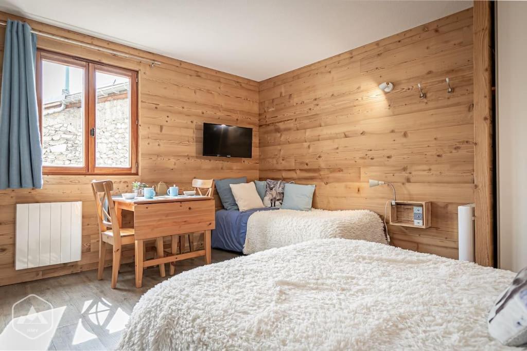 1 dormitorio con 2 camas, escritorio y TV en Côté-Bourget 3 pers LA BELLE PLINIER proche La Norma Aussois, en Villarodin-Bourget