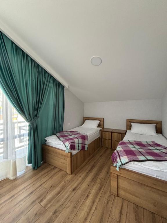 two beds in a room with a window at Diamond Bakuriani A6 in Bakuriani