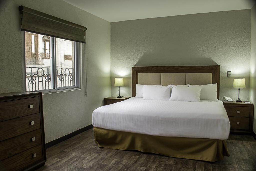 sypialnia z dużym łóżkiem i oknem w obiekcie Hotel Adriana w mieście Hidalgo del Parral