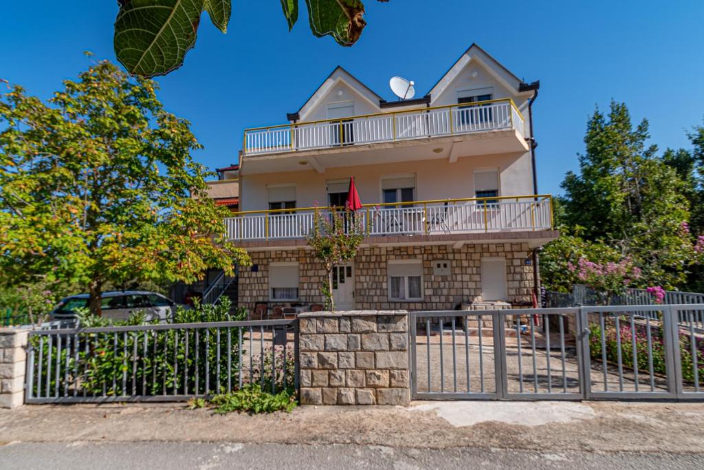 a house with a fence in front of it at Apartment Kesten in Janjina