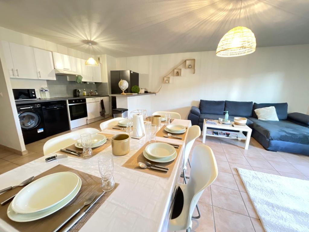 een keuken en een woonkamer met een tafel en stoelen bij Résidence aux portes de Genève in Annemasse