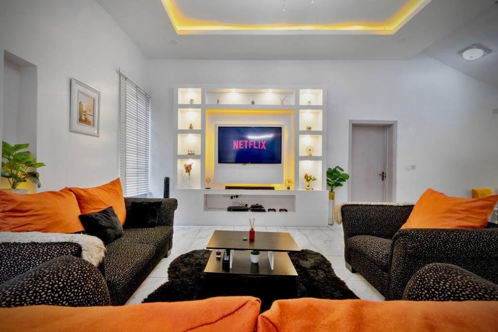 uma sala de estar com dois sofás e uma televisão em Skyfall em Lekki