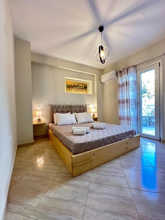 a bedroom with a large bed and a window at Olea Luxury Apartment in Pythagoreio