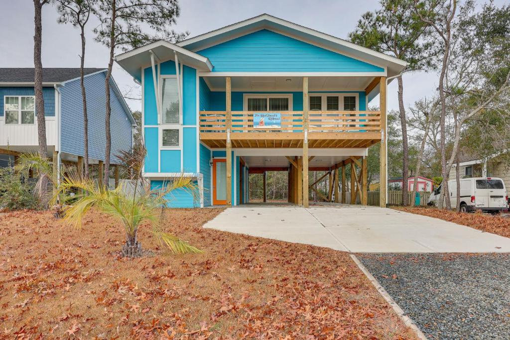 uma casa azul com um alpendre e um deque em Oak Island Coastal Home with Covered Deck! em Oak Island