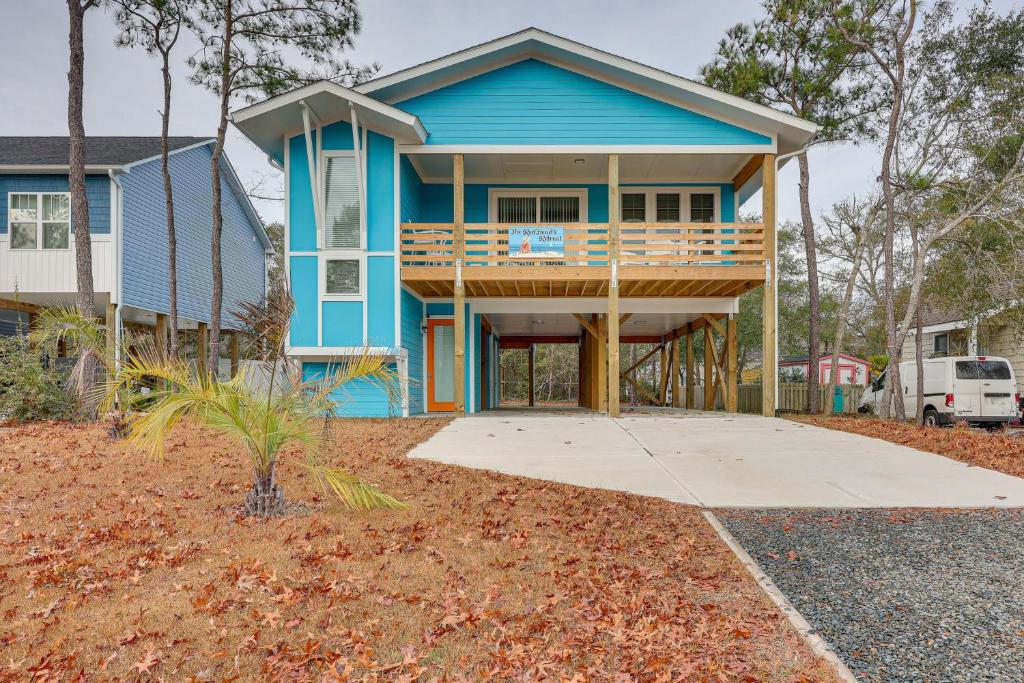 a blue house with a porch and a deck at Oak Island Fall Getaway Coastal Home and Deck in Oak Island