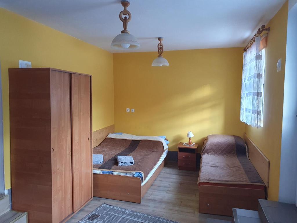 two beds in a room with yellow walls at Pokoje Gościnne Barbara in Ustroń
