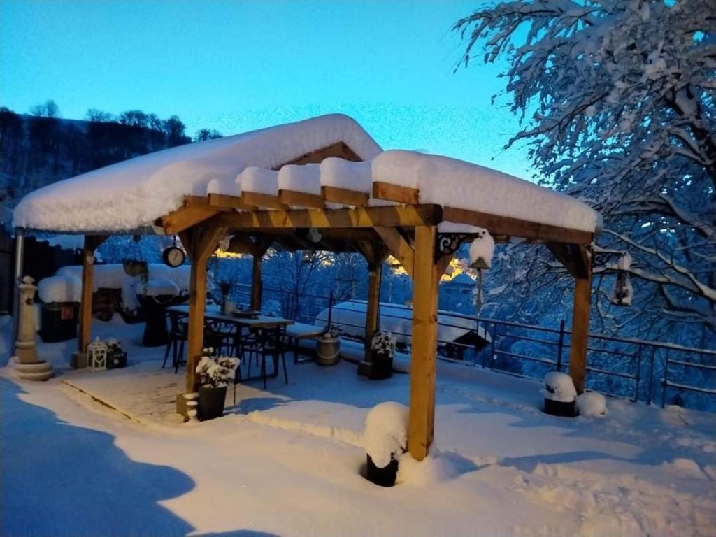 a wooden gazebo with snow on top of it at The Little Blue House in Reşiţa