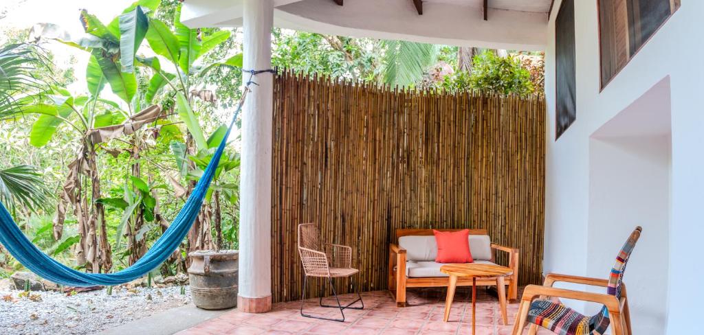 un patio con sillas y una hamaca en Encanta La Vida, en Cabo Matapalo