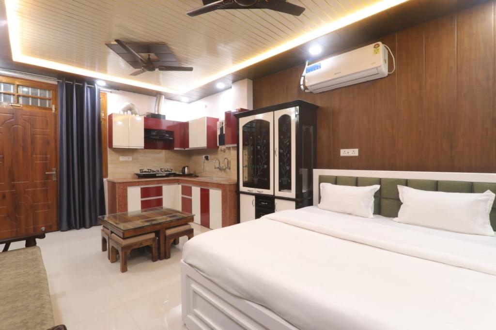 a bedroom with a large bed and a kitchen at Bk homestay in Lucknow