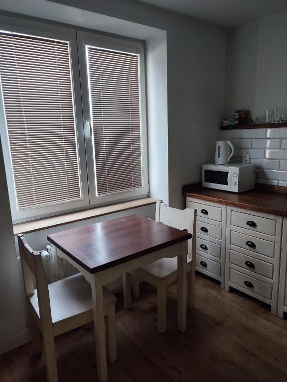 een keuken met een tafel en stoelen en een magnetron bij Bulvár apartmán in Žilina