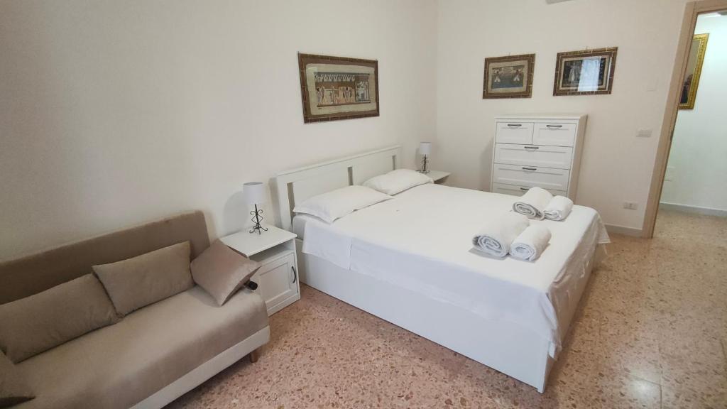 1 dormitorio con cama blanca y sofá en Luna Normanna, en Rutigliano