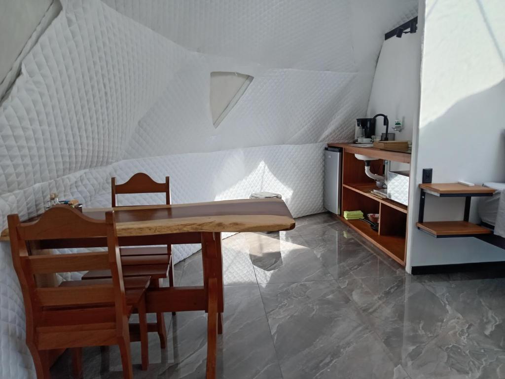 um quarto com uma mesa e cadeiras e uma cozinha em Glamping Karl em Monteverde