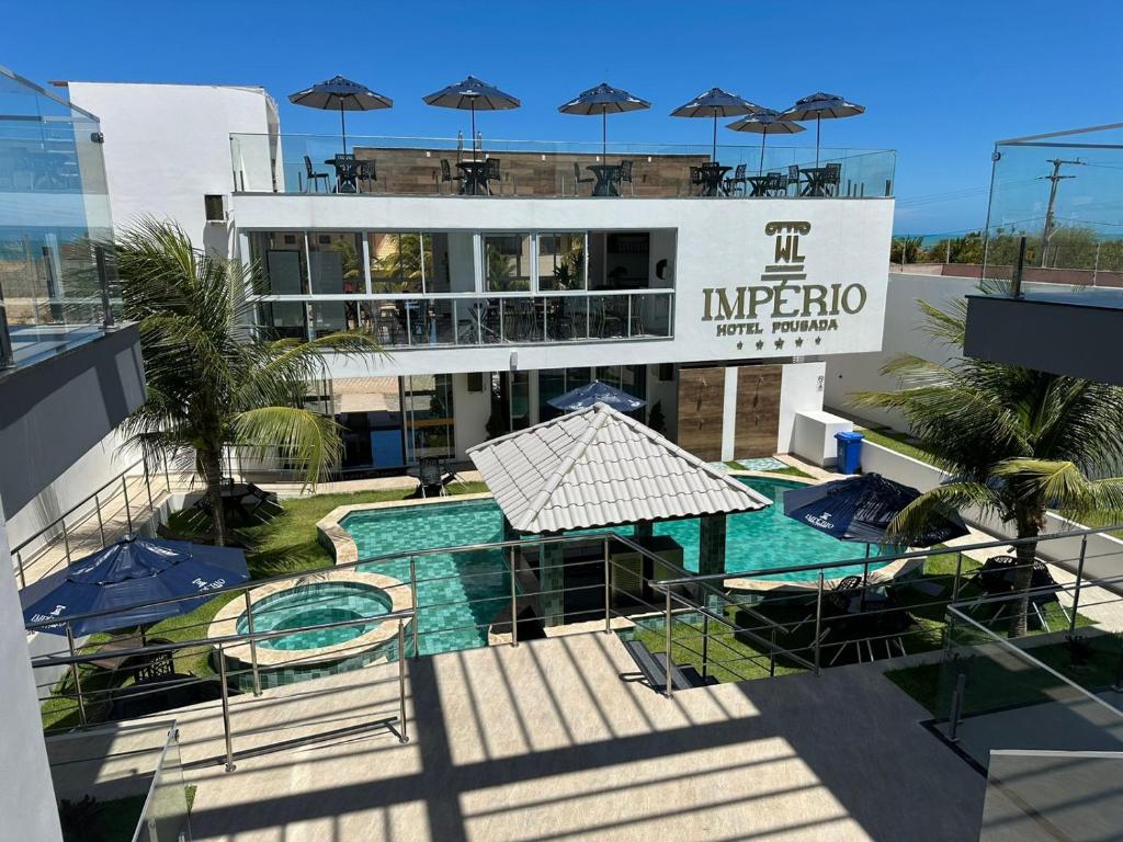 a building with a swimming pool and a hotel at Pousada WL Império in Canoa Quebrada