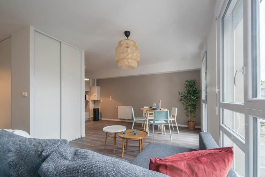 uma sala de estar com um sofá e uma mesa em NATHAN - Appartement proche gare arrivée 2424 em Le Mans